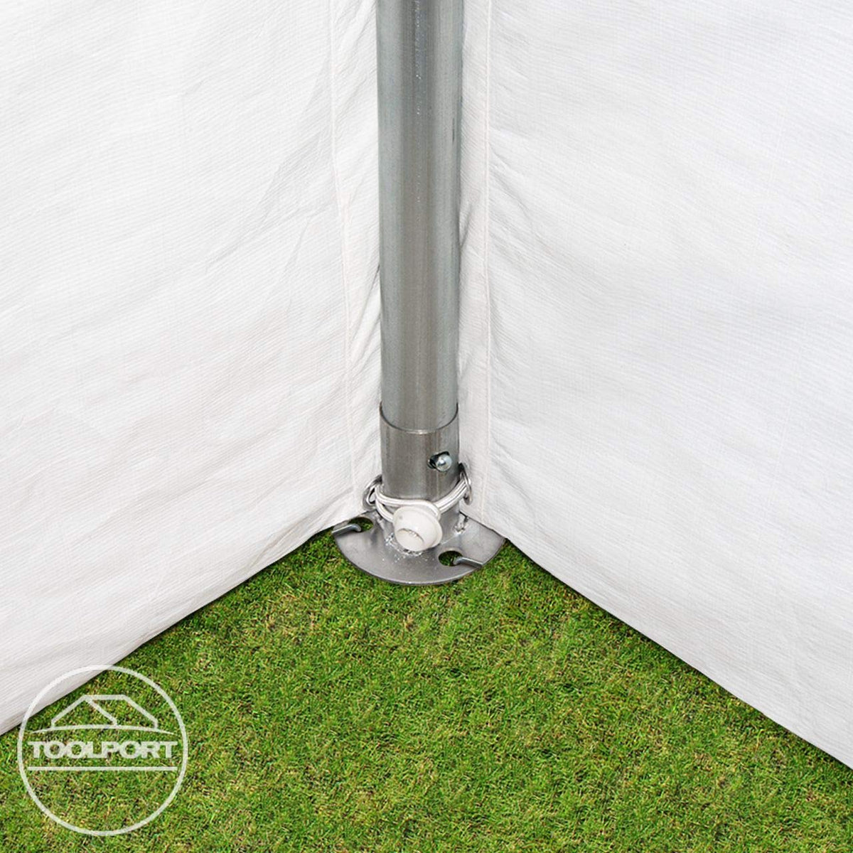 Corner base plate with vertical pole anchored to grass and secured with a grommeted cord