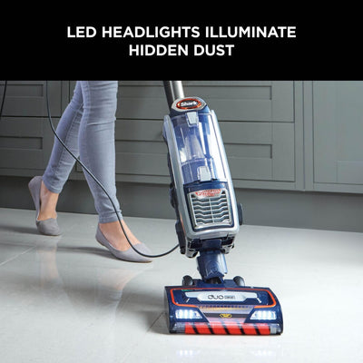 Close-up of the DuoClean floorhead with LED headlights and the upright vacuum's clear dust cup on a tiled floor.
