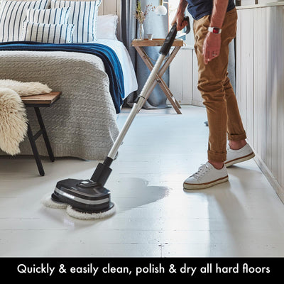 Person using PowerGlide in a bedroom to clean painted wood floor, twin pads and wet cleaning visible