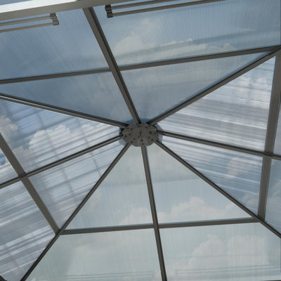 Interior upward view of the gazebo showing the central roof hub and radial aluminium supports beneath the panels.